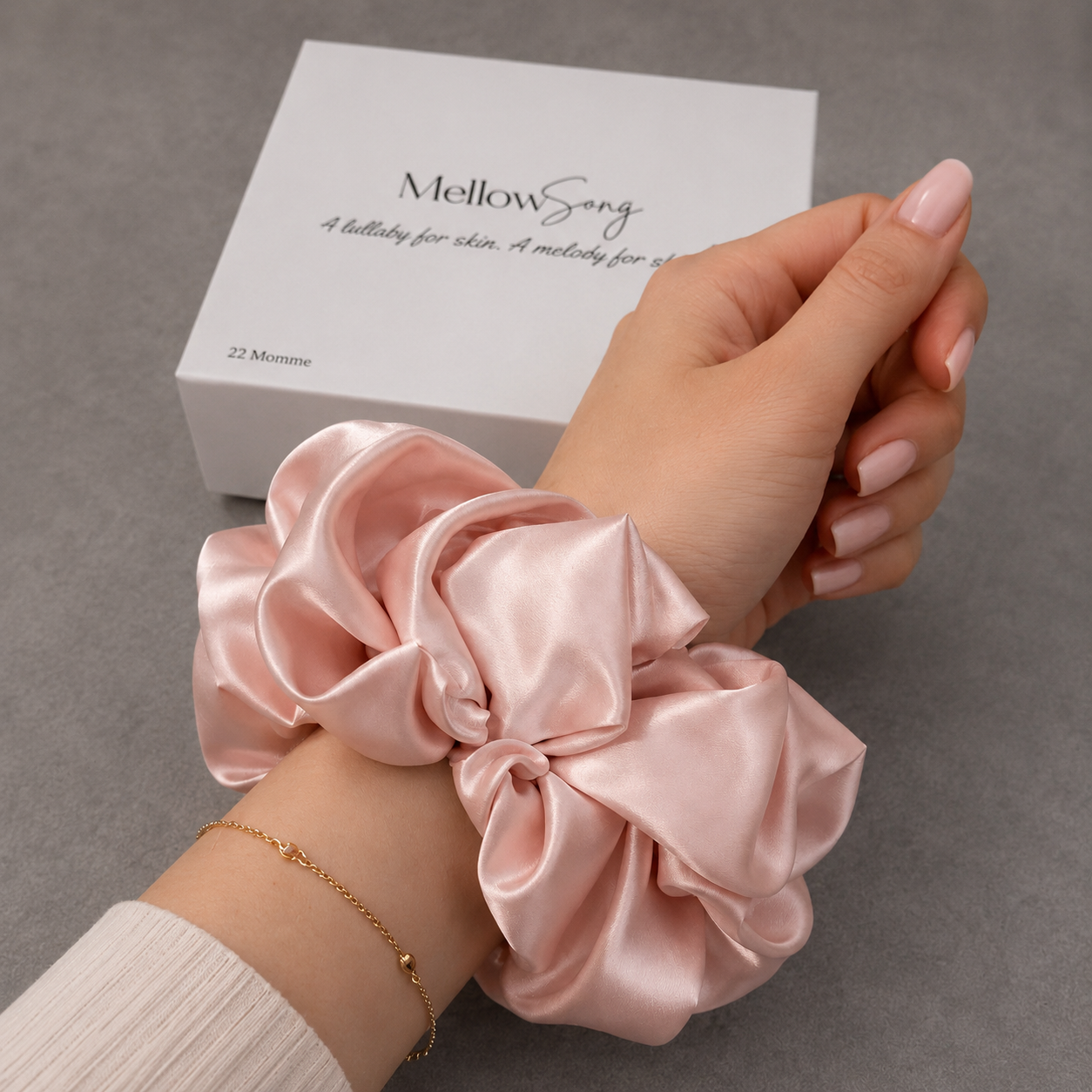 Champagne silk grant pink scrunchie worn as an elegant wrist accessory