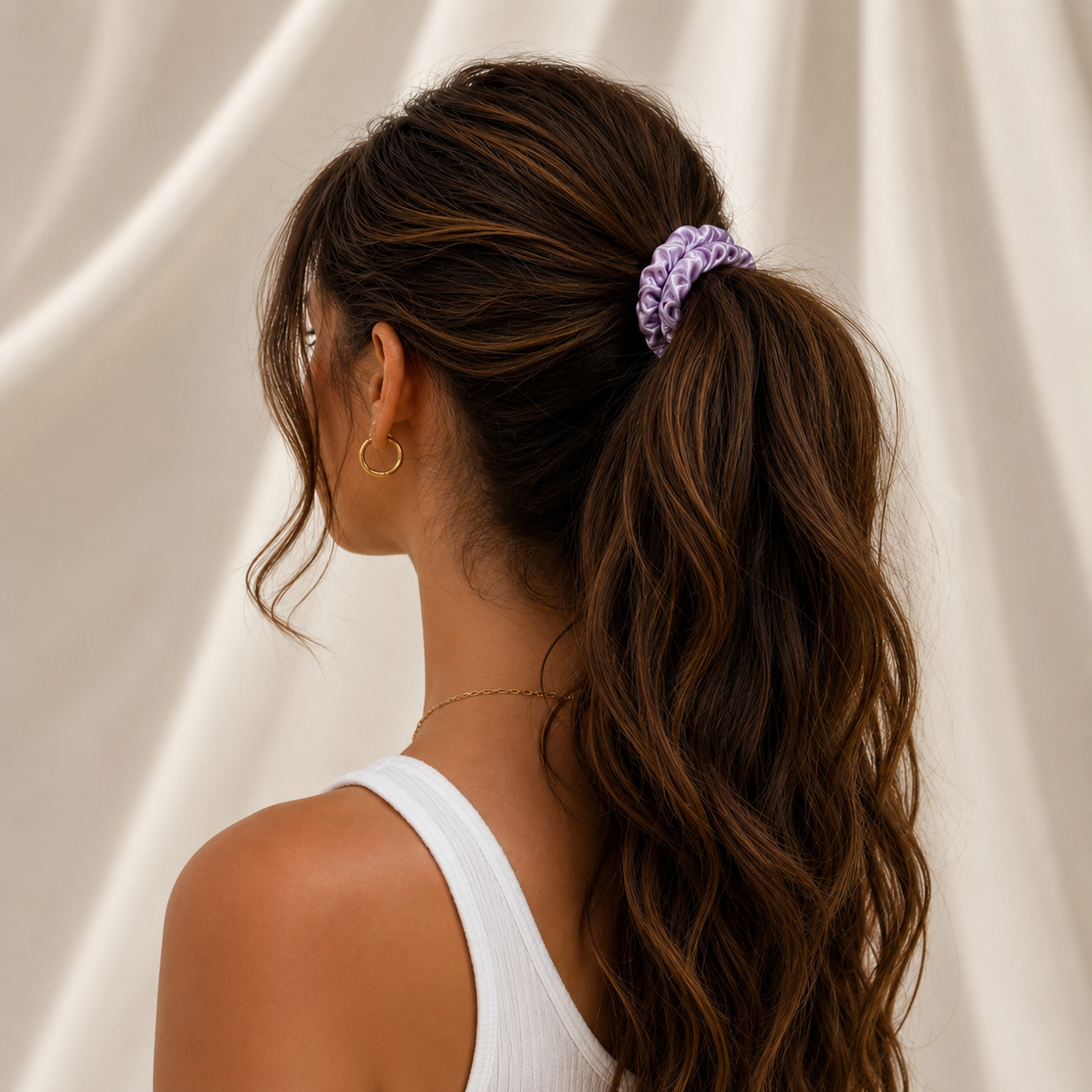 Woman wearing a champagne silk lilac scrunchie in a low ponytail hairstyle