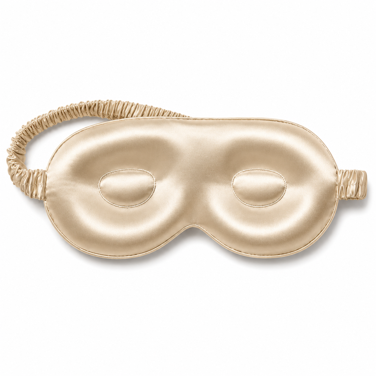 Champagne gold contoured silk sleep mask with a matching ruched elastic strap, isolated on a plain white background.