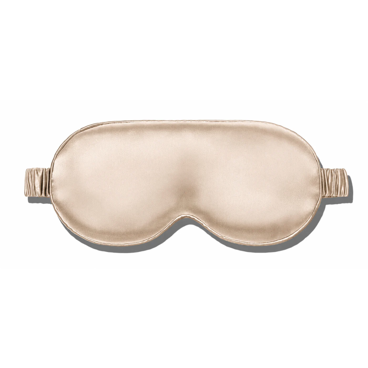 Champagne gold silk sleep mask with a matching ruched elastic strap, isolated on a plain white background.