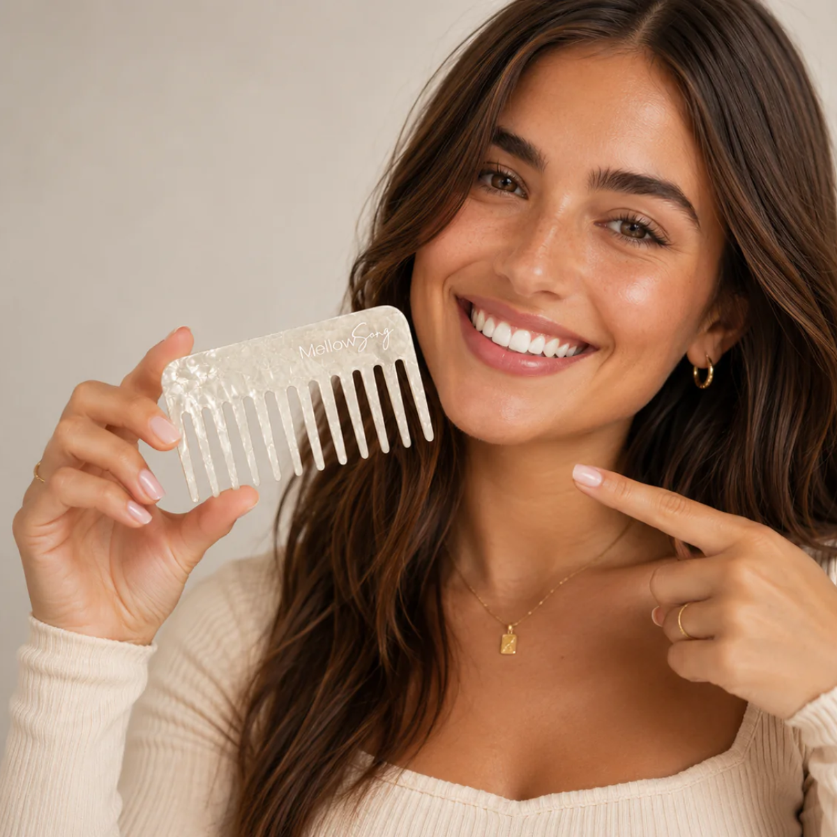 Woman holding a clear comb and smiling, with a neutral background