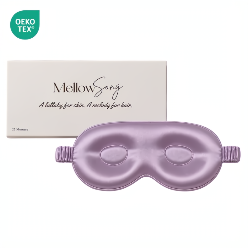 Lavender contoured silk eye mask by Mellow Song, shown with its original white packaging box and an OEKO-TEX logo on a plain white background.
