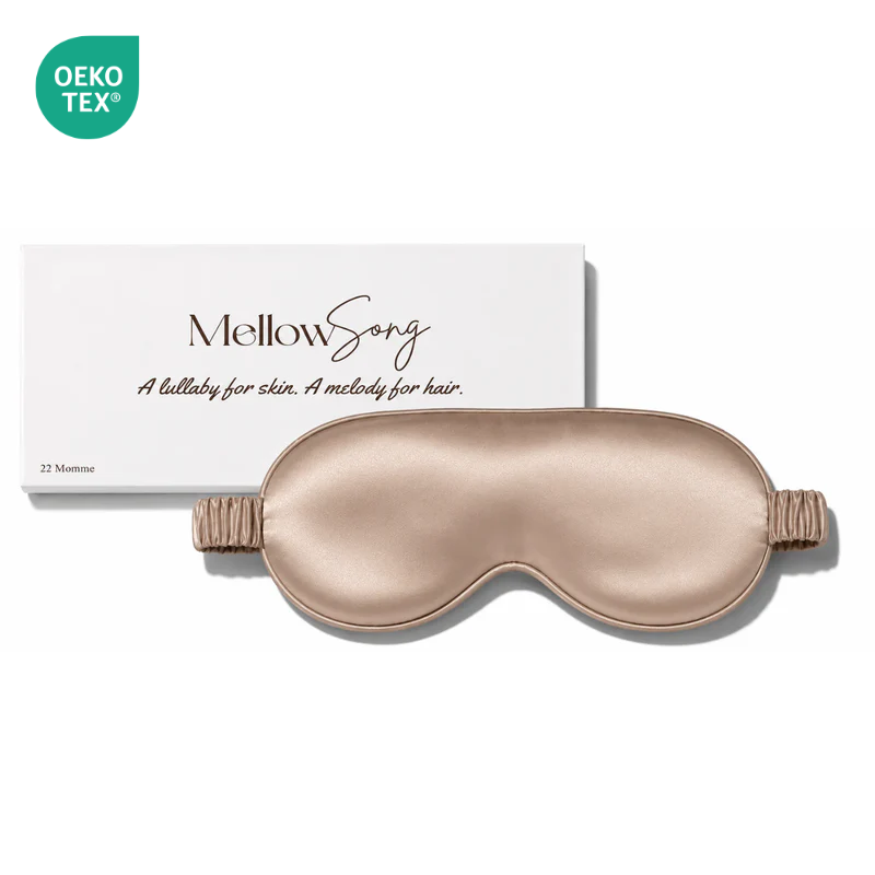 Luxury champagne gold 22 Momme mulberry silk sleep mask with elastic silk-covered strap, displayed with premium Mellow Song packaging.