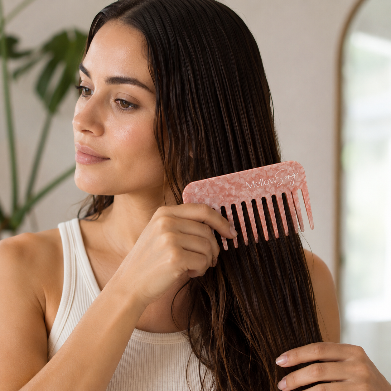 Woman combing her hair with a pink comb in a bathroom setting